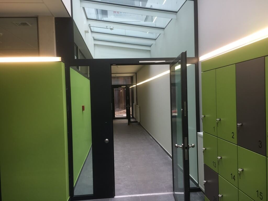 Geöffnete schwarze JVA-Durchgangstüren in einem Flur